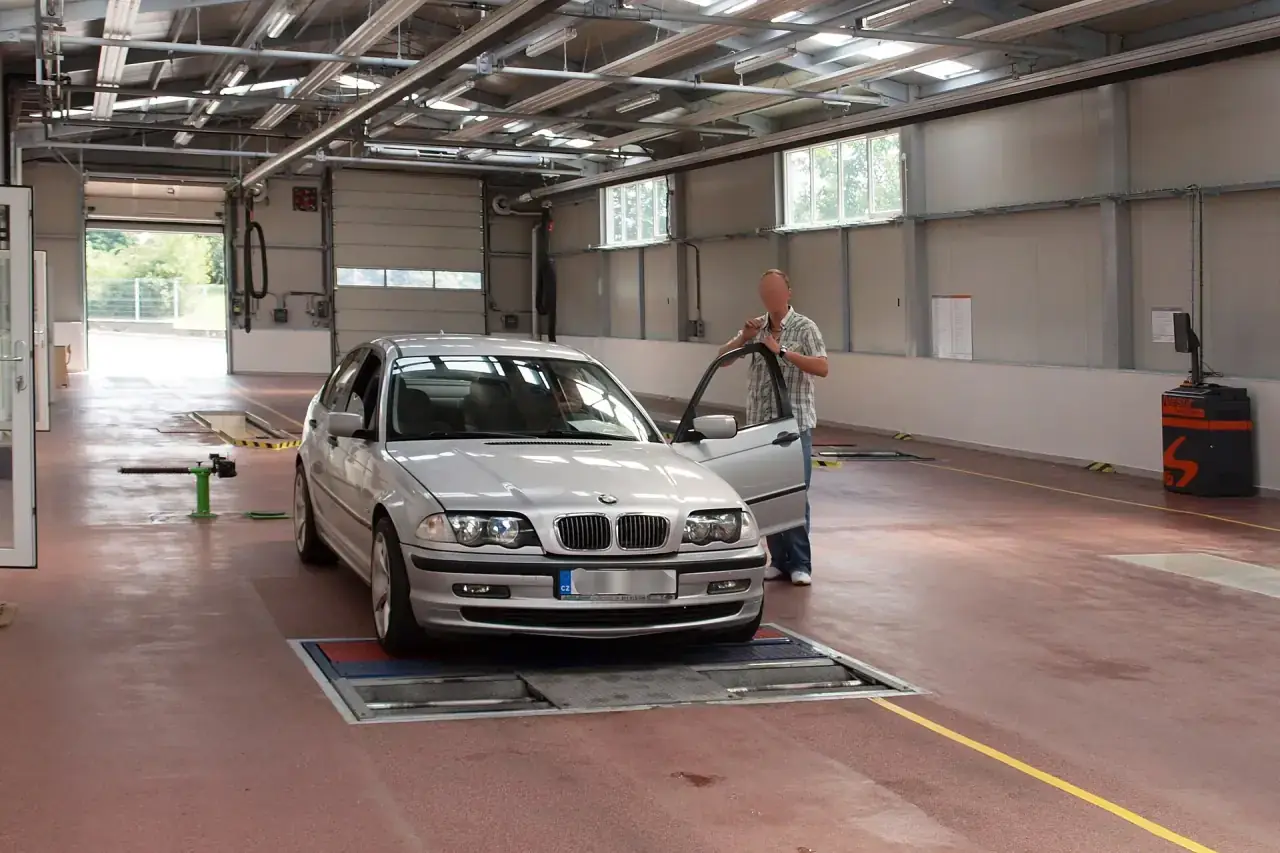 A vehicle undergoing a brake test on rollers at an inspection station.