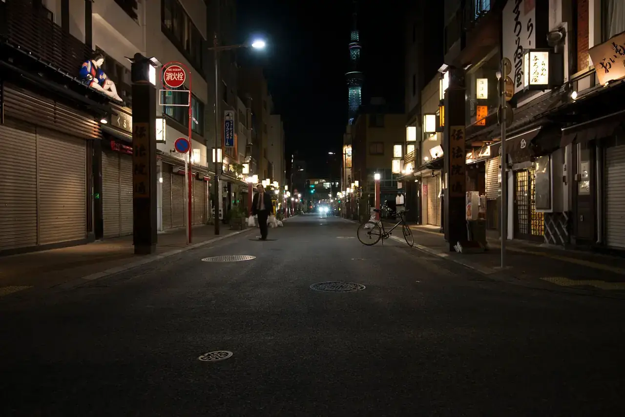 A quiet Tokyo street after dark, rendered in near-monochrome.